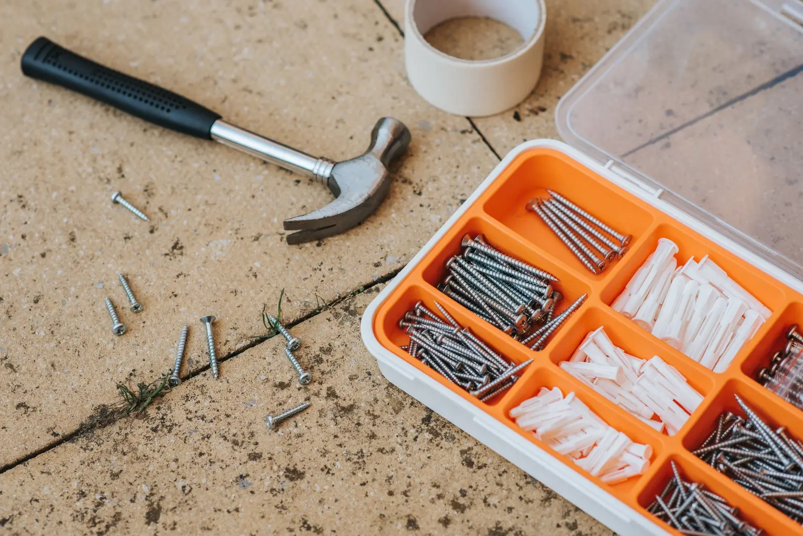 Hammer, nails and wall anchors laid out for a handyman repair job